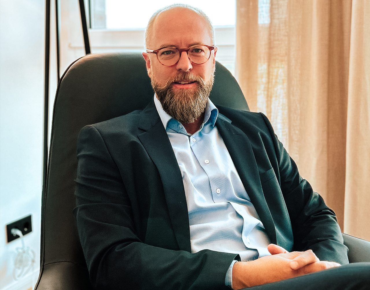 Die OPATZ Management GmbH kümmert sich um übergeordnete Aufgaben. Ein Mitarbeiter lächelt in einer Gesprächssituation.